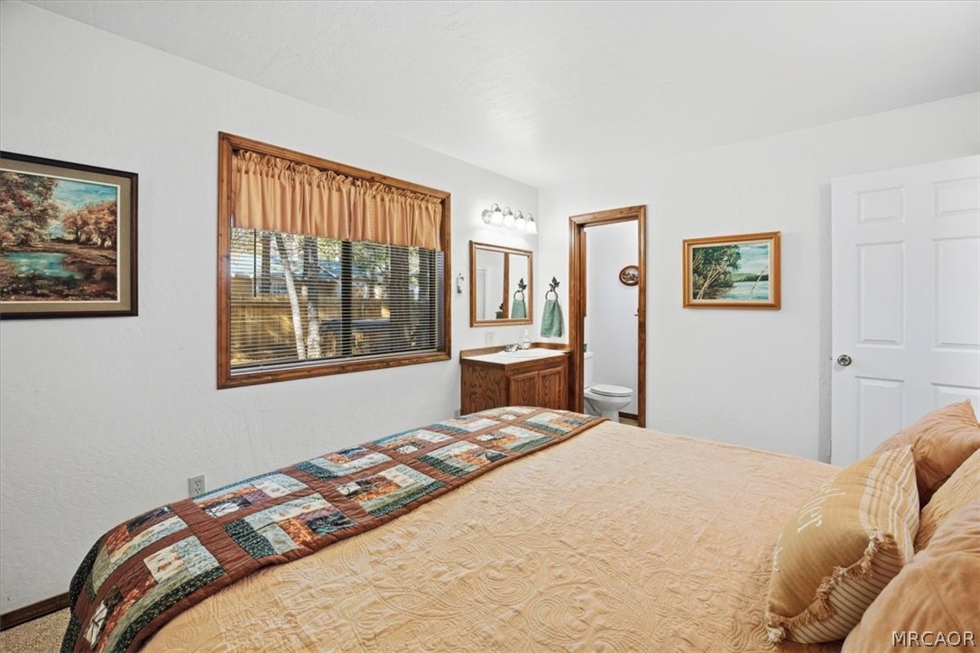 358 Victoria Lane Sugarloaf, CA 92386 - Photo 22 of 38 a bedroom with a large bed and a window