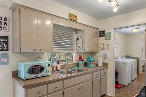 a kitchen with stainless steel appliances a sink a refrigerator and cabinets