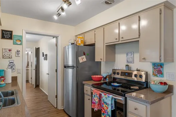 a kitchen that has a lot of cabinets a stove and a refrigerator