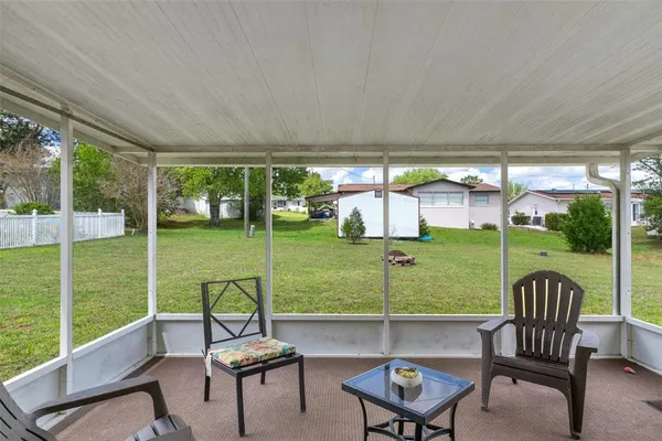 a view of a chairs and table in patio with a yard