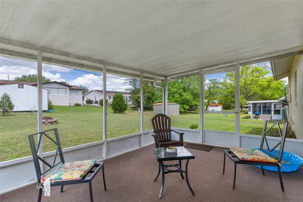 a view of a chairs and table in patio with a yard