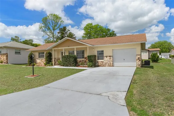 a front view of a house with a garden and trees