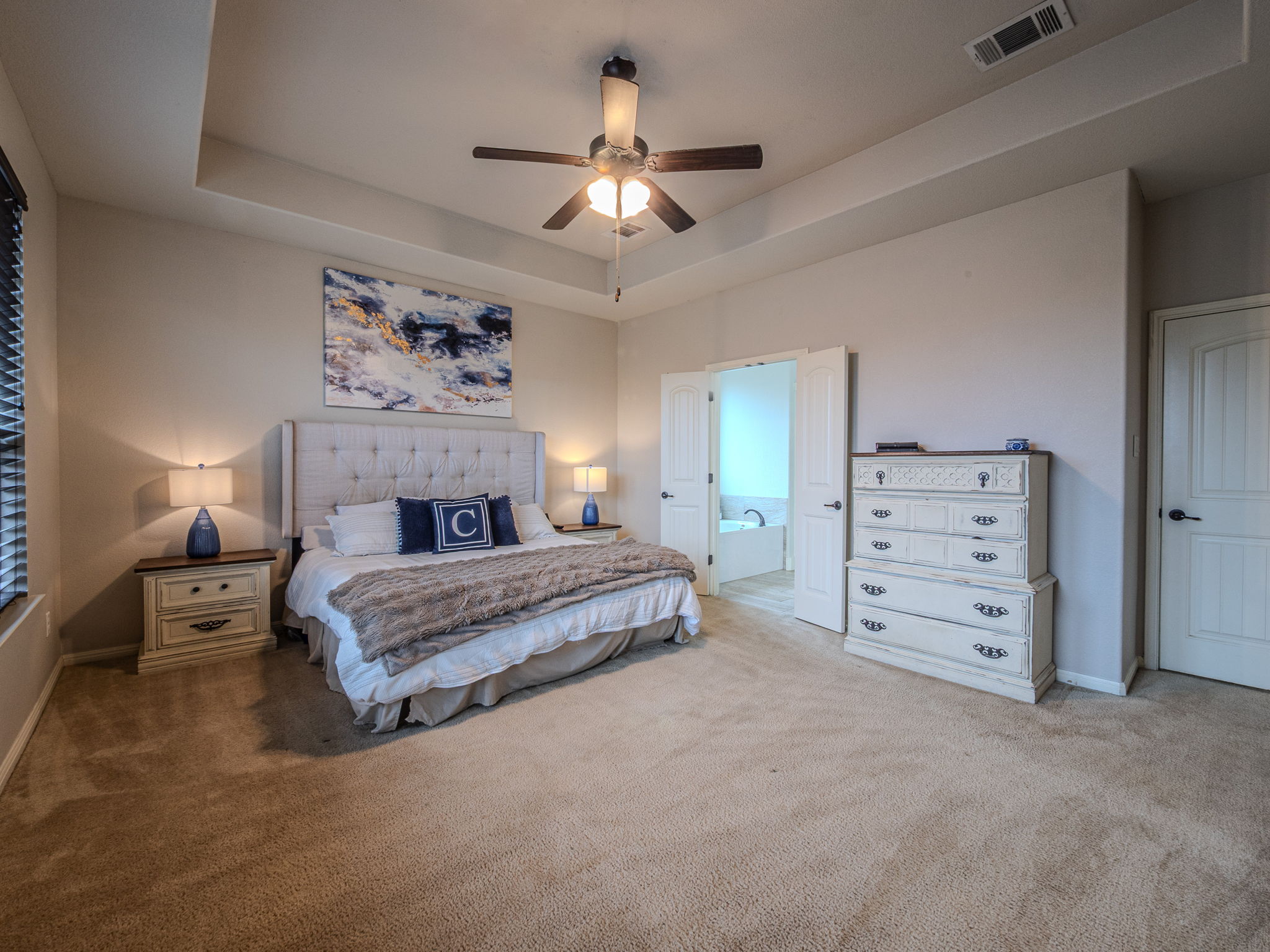 117 Arbor Point Drive Elgin, TX 78621 - Photo 15 of 40 a spacious bedroom with a large bed and a chandelier