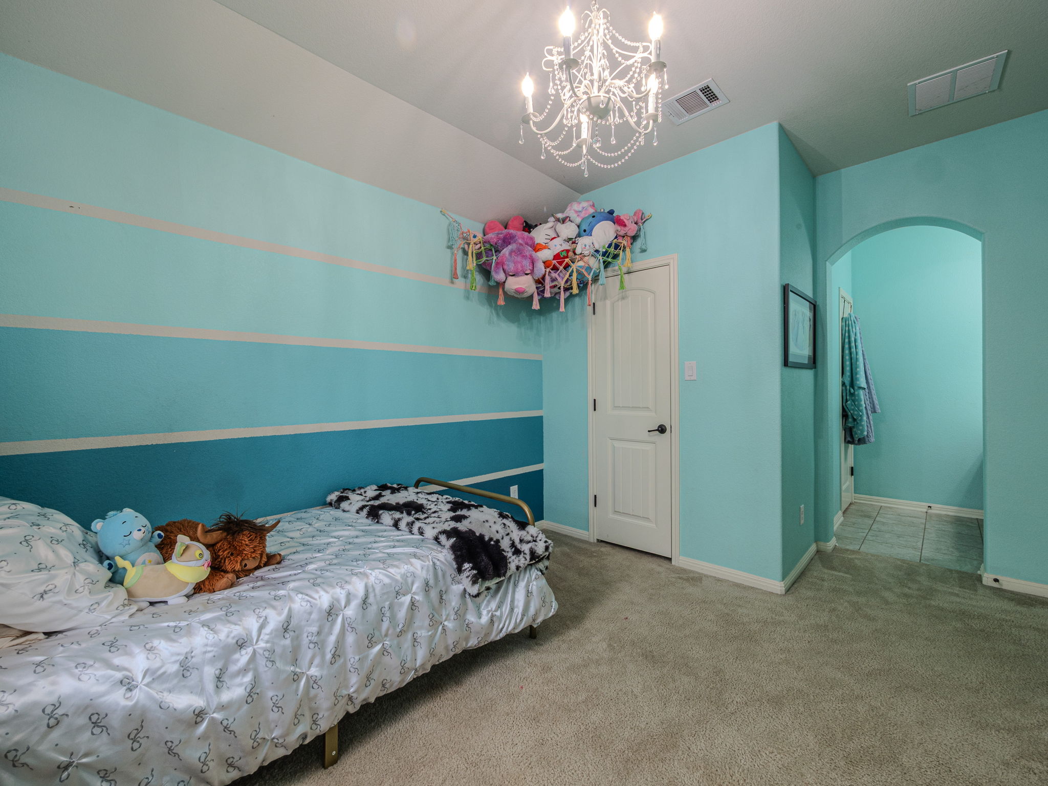 117 Arbor Point Drive Elgin, TX 78621 - Photo 24 of 40 a bedroom with a bed and a chandelier