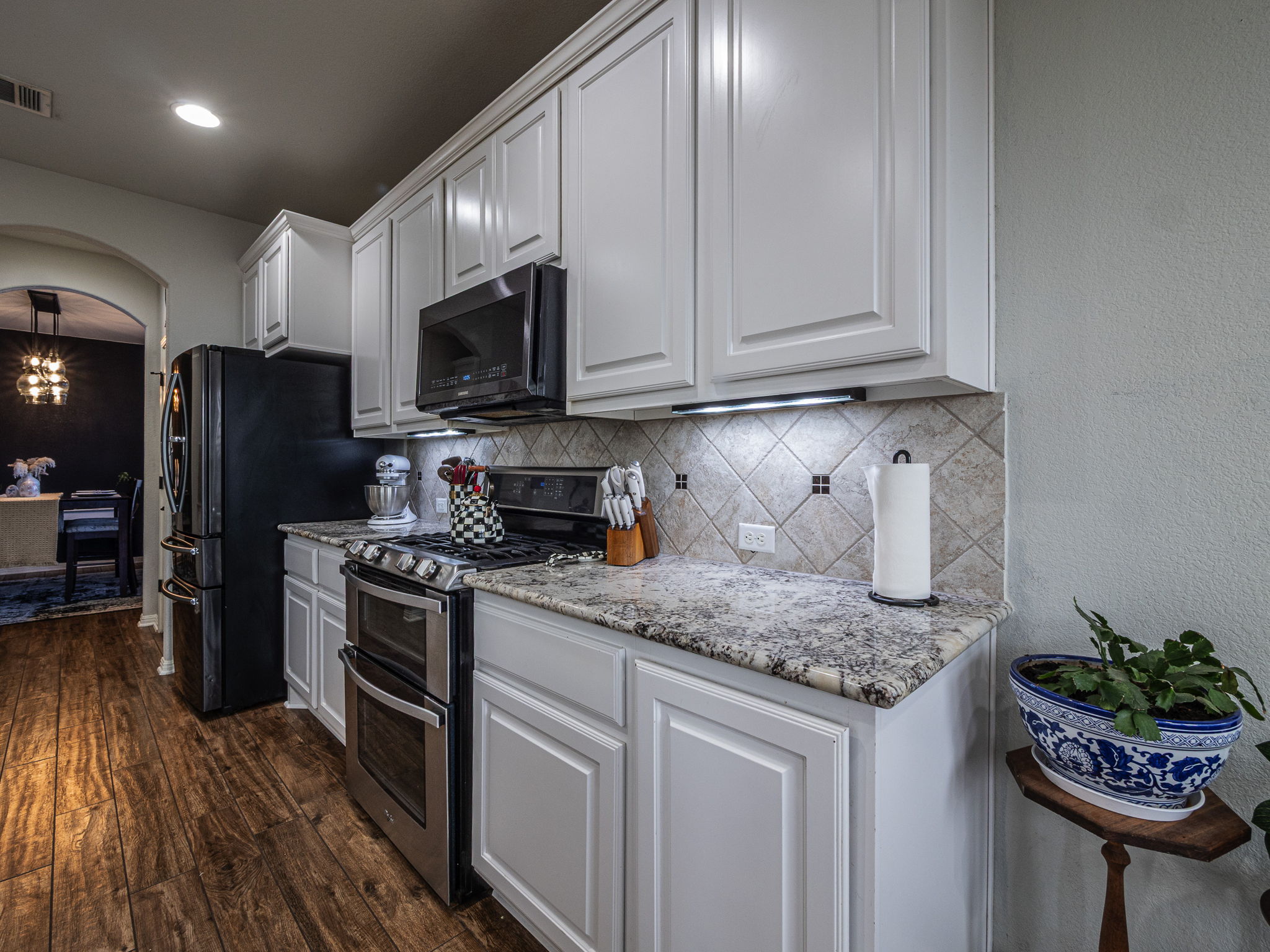 117 Arbor Point Drive Elgin, TX 78621 - Photo 8 of 40 a kitchen with stainless steel appliances granite countertop a refrigerator sink stove microwave and cabinets