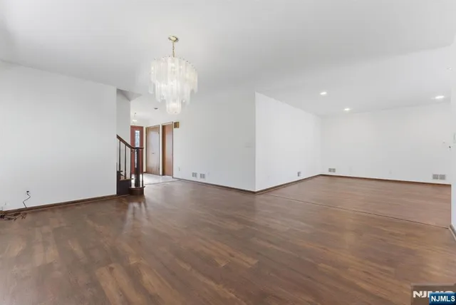 an empty room with wooden floor and ceiling fan
