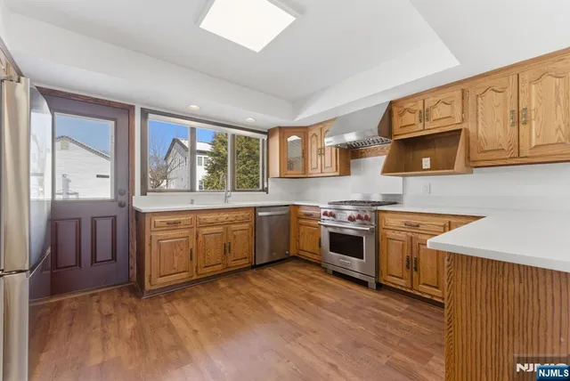a kitchen with stainless steel appliances granite countertop a stove a sink and a microwave