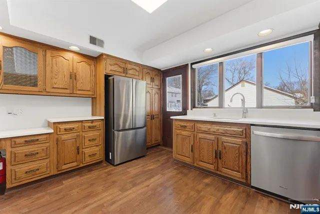 a kitchen with stainless steel appliances granite countertop a refrigerator sink and cabinets