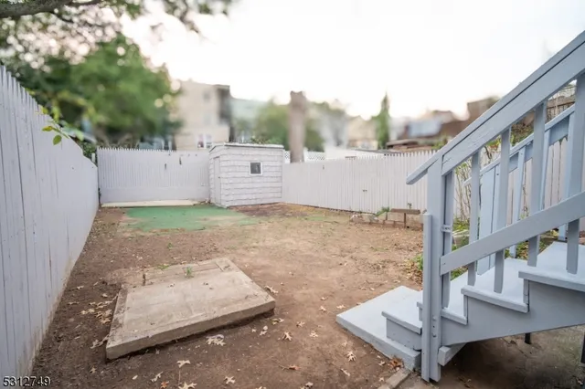 a view of a small house with wooden fence