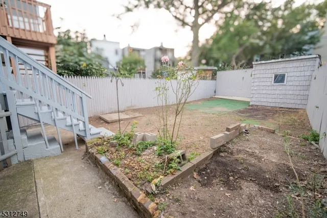 a view of a backyard with wooden fence