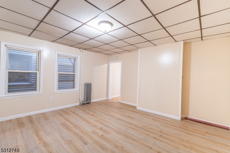 124 Stone Street, Unit 2 Newark, NJ 07104 - Photo 15 of 27 a view of an empty room with a window and wooden floor