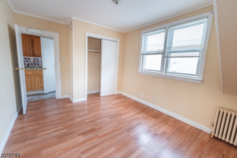 124 Stone Street, Unit 2 Newark, NJ 07104 - Photo 7 of 27 a view of an empty room with wooden floor and a window