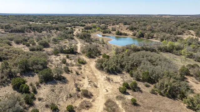 a view of a lake in middle of a field
