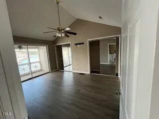 a view of an empty room with window and wooden floor