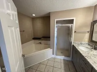 a bathroom with a granite countertop sink a mirror and a bathtub