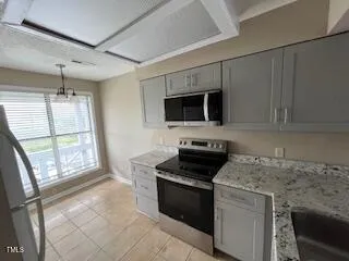 a kitchen with stainless steel appliances granite countertop a stove microwave and refrigerator