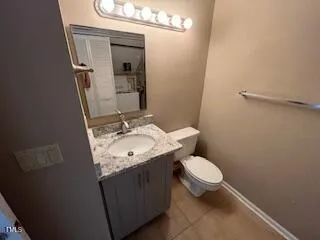 a bathroom with a granite countertop toilet and a sink