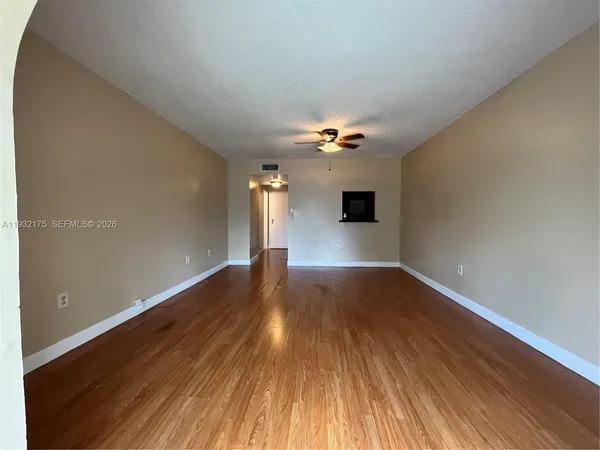 a view of an empty room with wooden floor