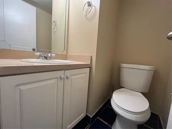 a bathroom with a granite countertop toilet sink and mirror