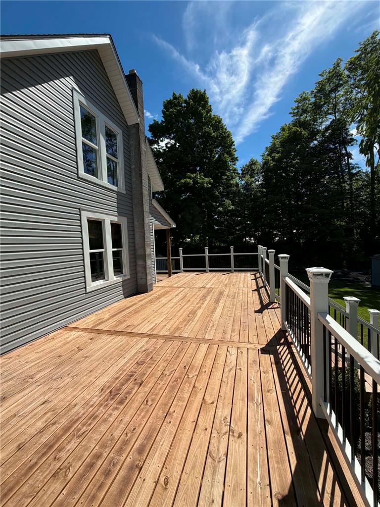 164 Sand Spring Road Cresco, PA 18326 - Photo 14 of 60 A spacious wooden deck extends from a home with light gray siding, perfect for outdoor enjoyment.