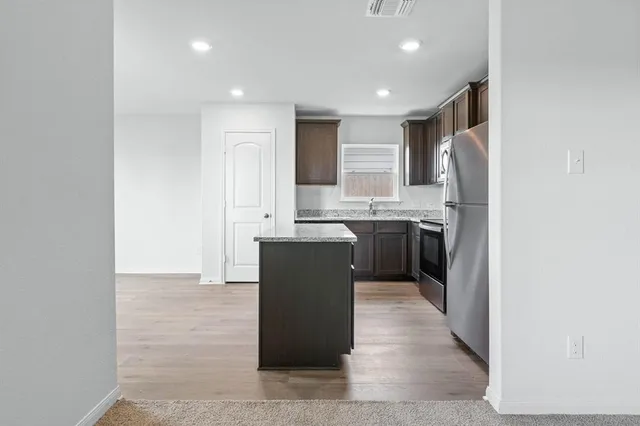 a kitchen with stainless steel appliances granite countertop a sink a stove and a refrigerator