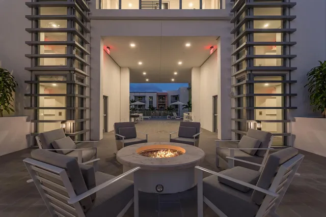 a living room with furniture and a view of kitchen
