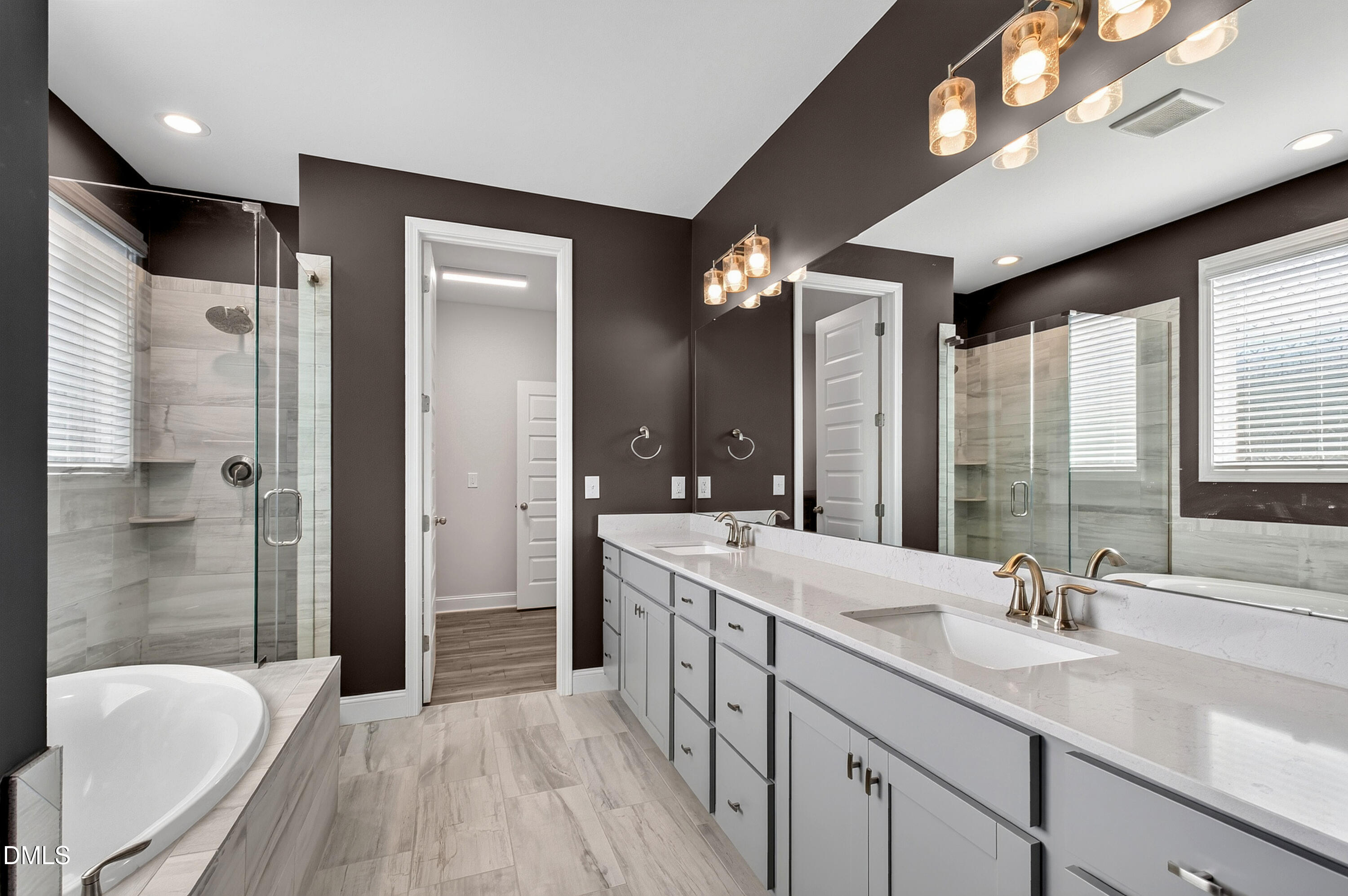 1300 Commons Ford Place Apex, NC 27539 - Photo 31 of 70 a spacious bathroom with a double vanity sink a large mirror and a shower