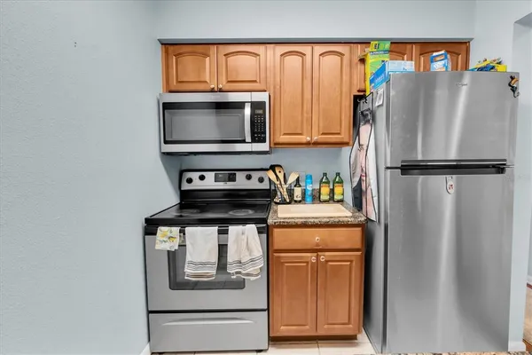 a white refrigerator freezer and a stove sitting inside of a kitchen