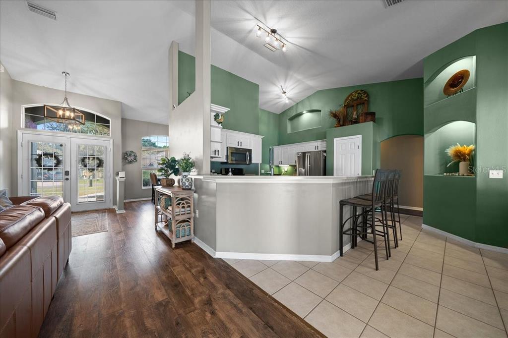 10080 Southeast 69th Terrace Belleview, FL 34420 - Photo 11 of 51 a living room with furniture a dining table and a chandelier