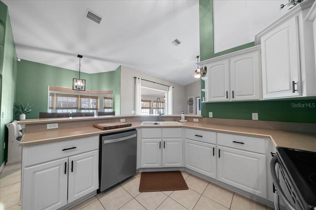 10080 Southeast 69th Terrace Belleview, FL 34420 - Photo 16 of 51 a kitchen with white cabinets and white appliances