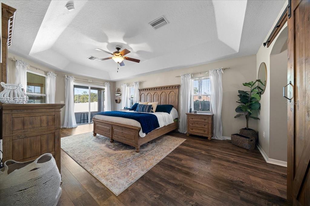 10080 Southeast 69th Terrace Belleview, FL 34420 - Photo 21 of 51 a spacious bedroom with a bed a dresser and potted plant on the dresser