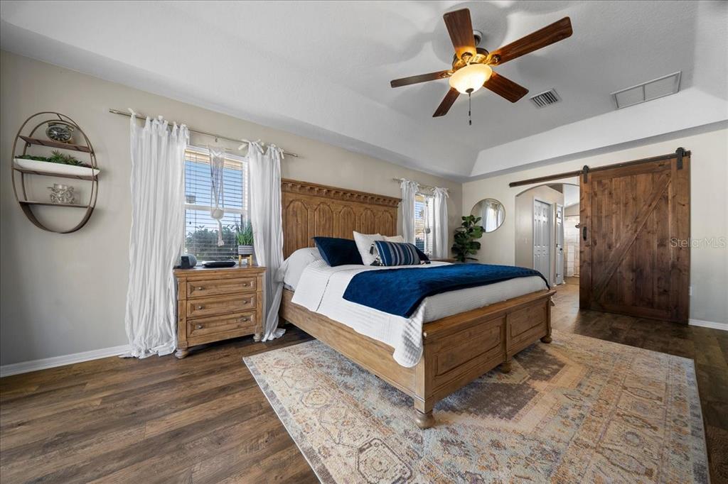 10080 Southeast 69th Terrace Belleview, FL 34420 - Photo 22 of 51 a bedroom with a bed and a chandelier