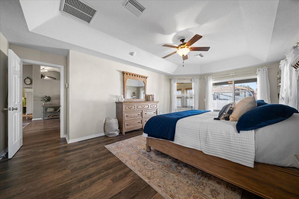 10080 Southeast 69th Terrace Belleview, FL 34420 - Photo 23 of 51 a bedroom with a large bed a chandelier and closet