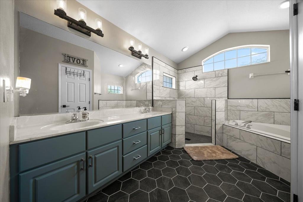 10080 Southeast 69th Terrace Belleview, FL 34420 - Photo 25 of 51 a bathroom with a double vanity sink mirror and bathtub