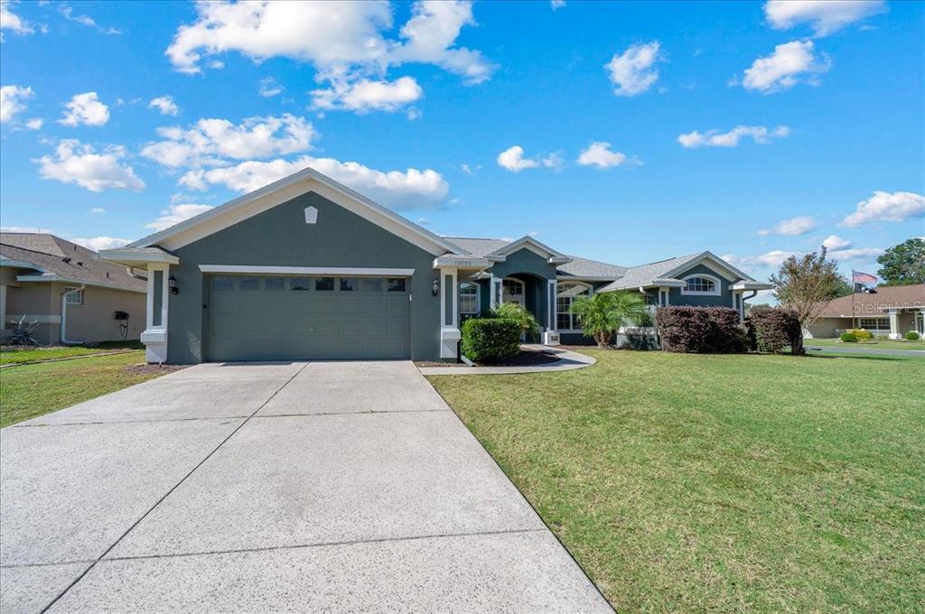 10080 Southeast 69th Terrace Belleview, FL 34420 - Photo 3 of 51 a front view of a house with a garden and yard