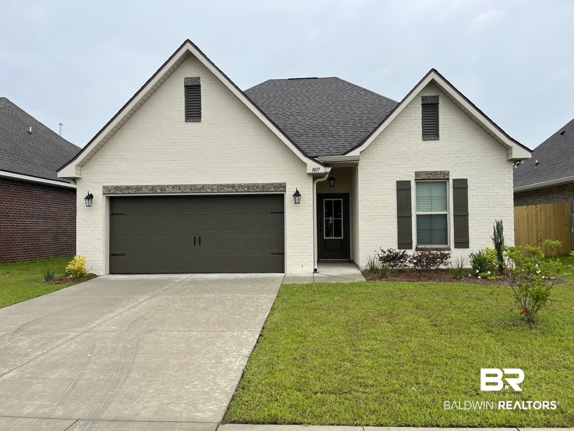 1407 Fenton Circle Foley, AL 36535 - Photo 1 of 3 Traditional-style house featuring driveway, brick siding, roof with shingles, and an attached garage