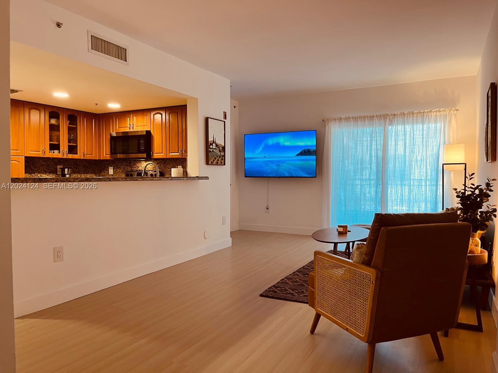 120 South Douglas Road, Unit 302 Miami, FL 33134 - Photo 4 of 28 a living room with furniture and a flat screen tv