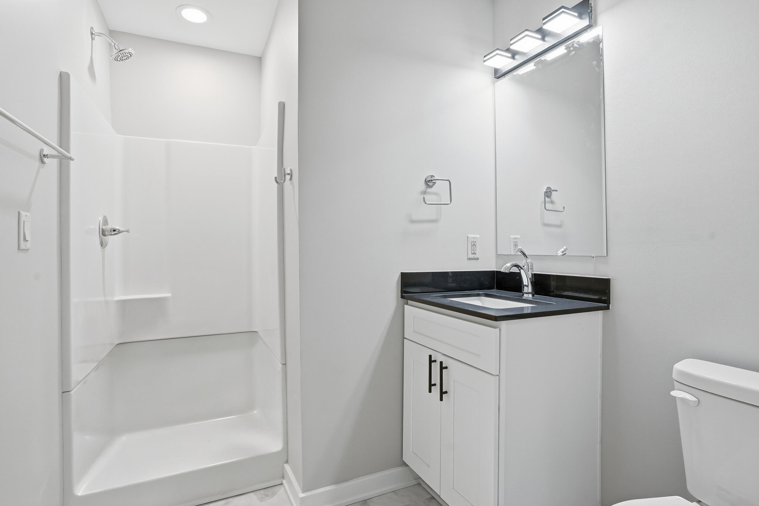 1540 119th Street, Unit 201 Whiting, IN 46394 - Photo 15 of 17 a bathroom with a granite countertop sink a toilet a mirror and shower