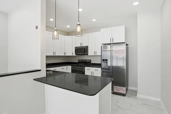 a kitchen with granite countertop white cabinets and white appliances