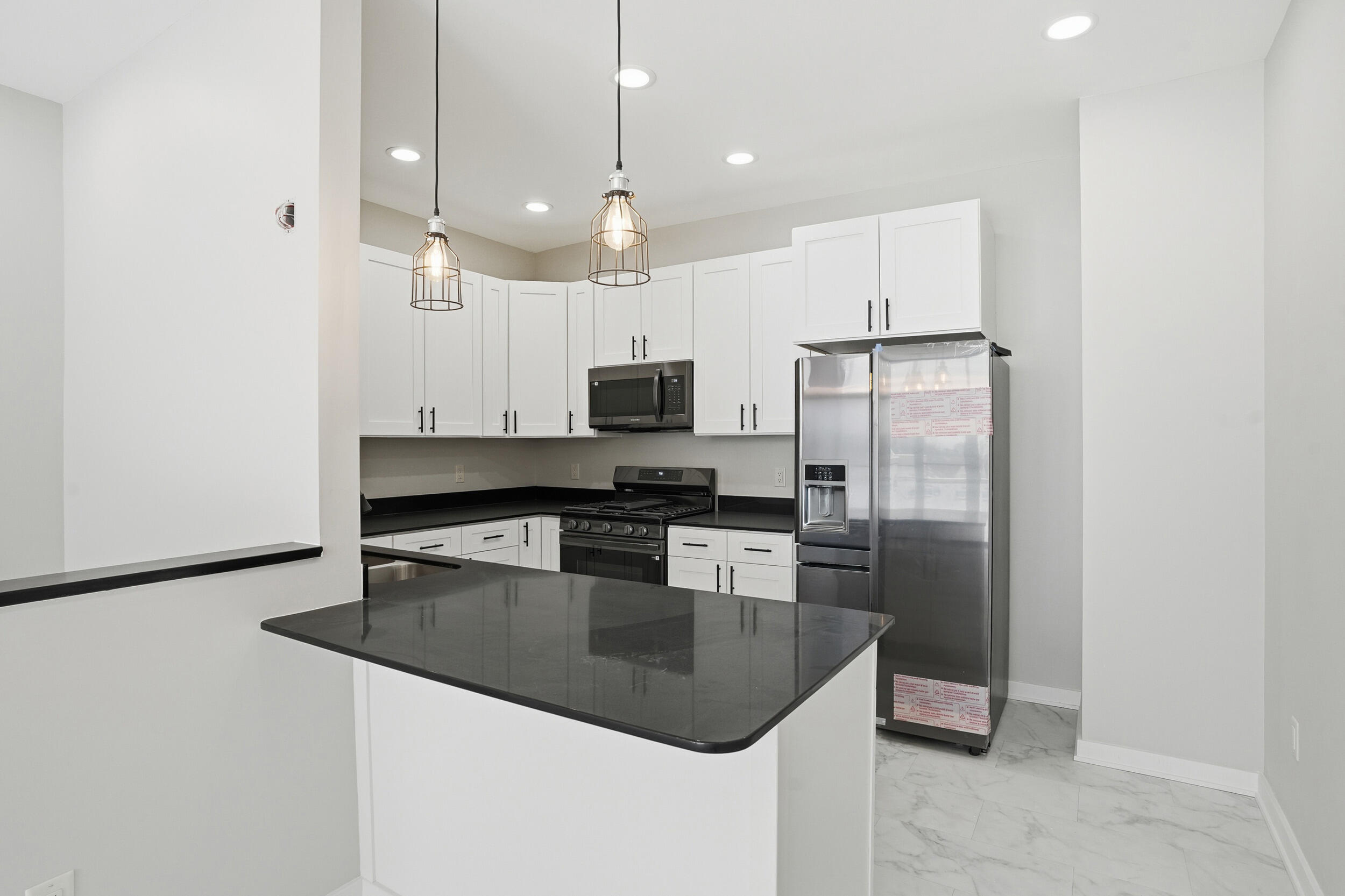 1540 119th Street, Unit 201 Whiting, IN 46394 - Photo 3 of 17 a kitchen with stainless steel appliances granite countertop a refrigerator a sink a stove a microwave and white cabinets