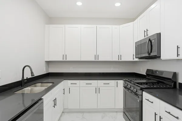 a large kitchen with a refrigerator and a stove