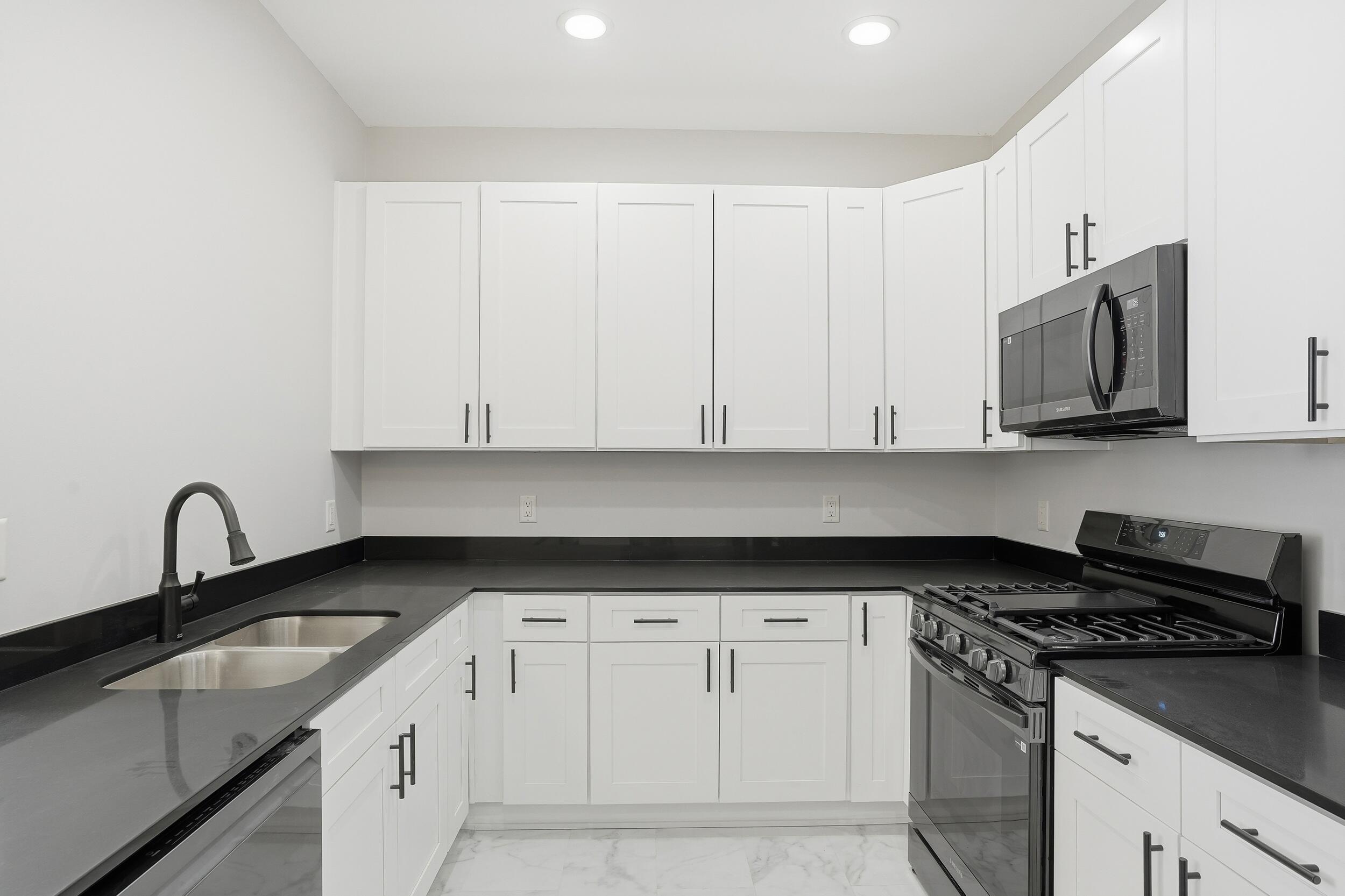 1540 119th Street, Unit 201 Whiting, IN 46394 - Photo 5 of 17 a kitchen with granite countertop white cabinets and sink