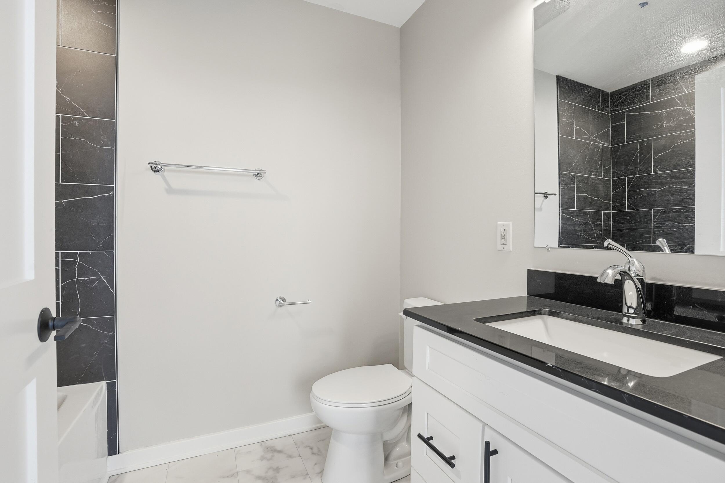 1540 119th Street, Unit 201 Whiting, IN 46394 - Photo 10 of 17 a bathroom with a granite countertop sink toilet and shower