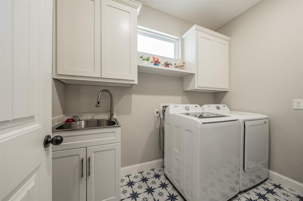 117 Rock Salt Drive Springtown, TX 76082 - Photo 24 of 38 Laundry room featuring patterned tile flooring, white shaker-style cabinetry, an under-mount stainless steel sink with a gooseneck faucet, and a high transom window