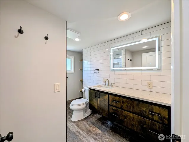 a bathroom with a toilet sink and mirror