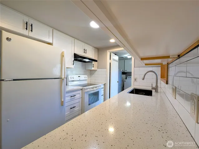 a kitchen with stainless steel appliances a refrigerator sink and cabinets