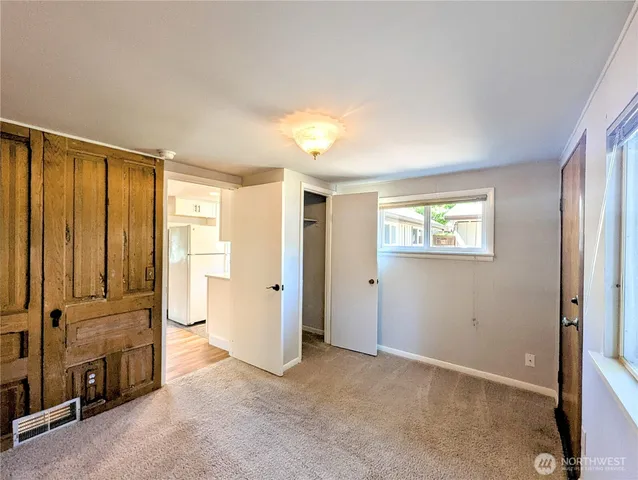 an empty room with windows and closet