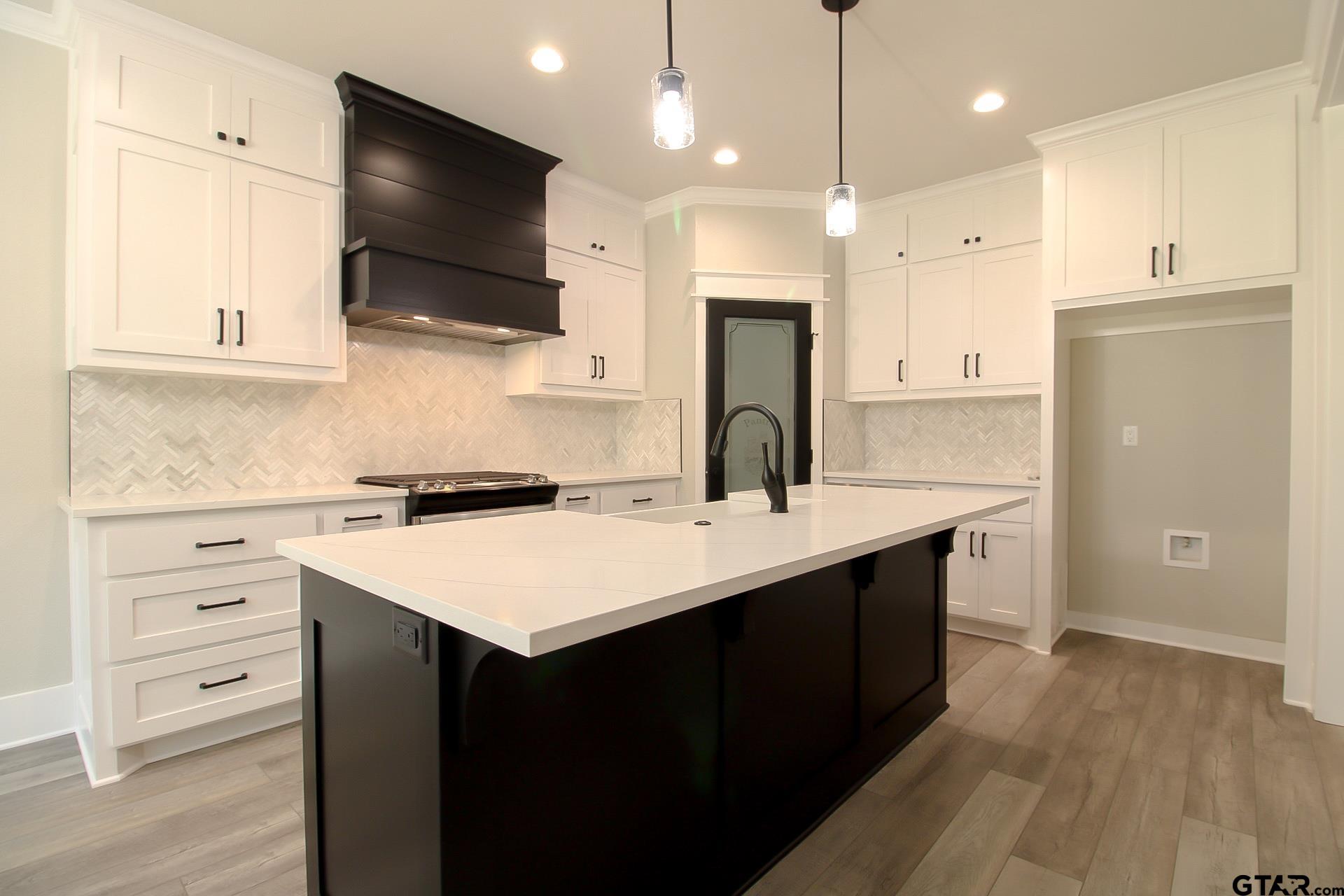 1069 Stagecoach Bend Bullard, TX 75757 - Photo 15 of 44 a kitchen with a sink a center island stainless steel appliances and cabinets