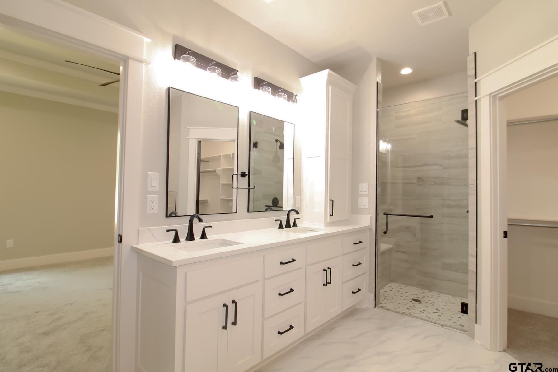 1069 Stagecoach Bend Bullard, TX 75757 - Photo 23 of 44 a bathroom with a double vanity sink mirror double shower and a bathtub