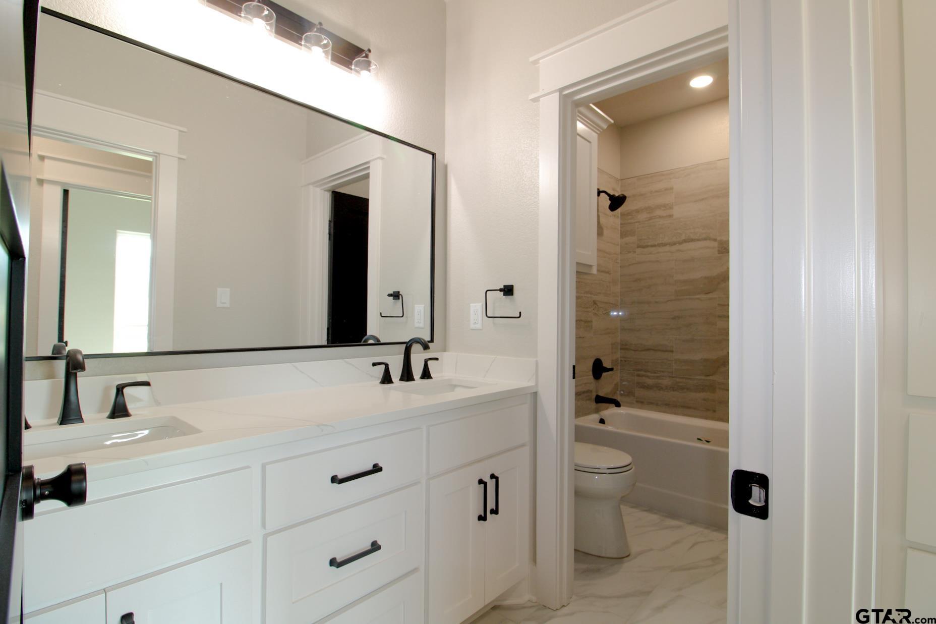 1069 Stagecoach Bend Bullard, TX 75757 - Photo 34 of 44 a bathroom with a double vanity sink toilet mirror and shower